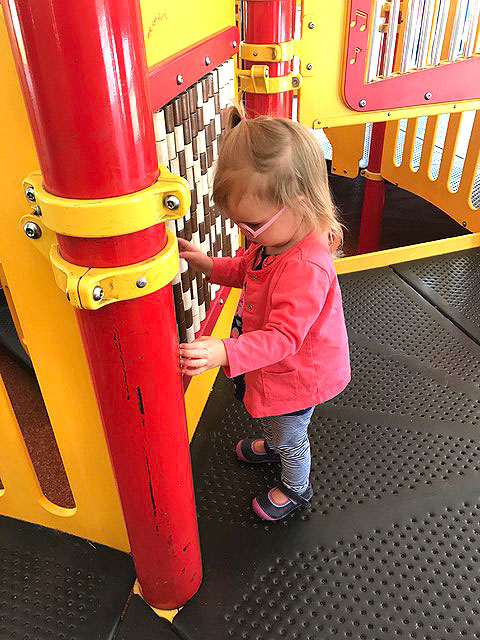 A little girl is playing at the sensory playground at Fairmount Park