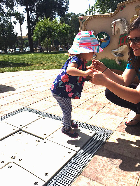 A little girl is playing on the musical squares at the sensory playground at Fairmount Park
