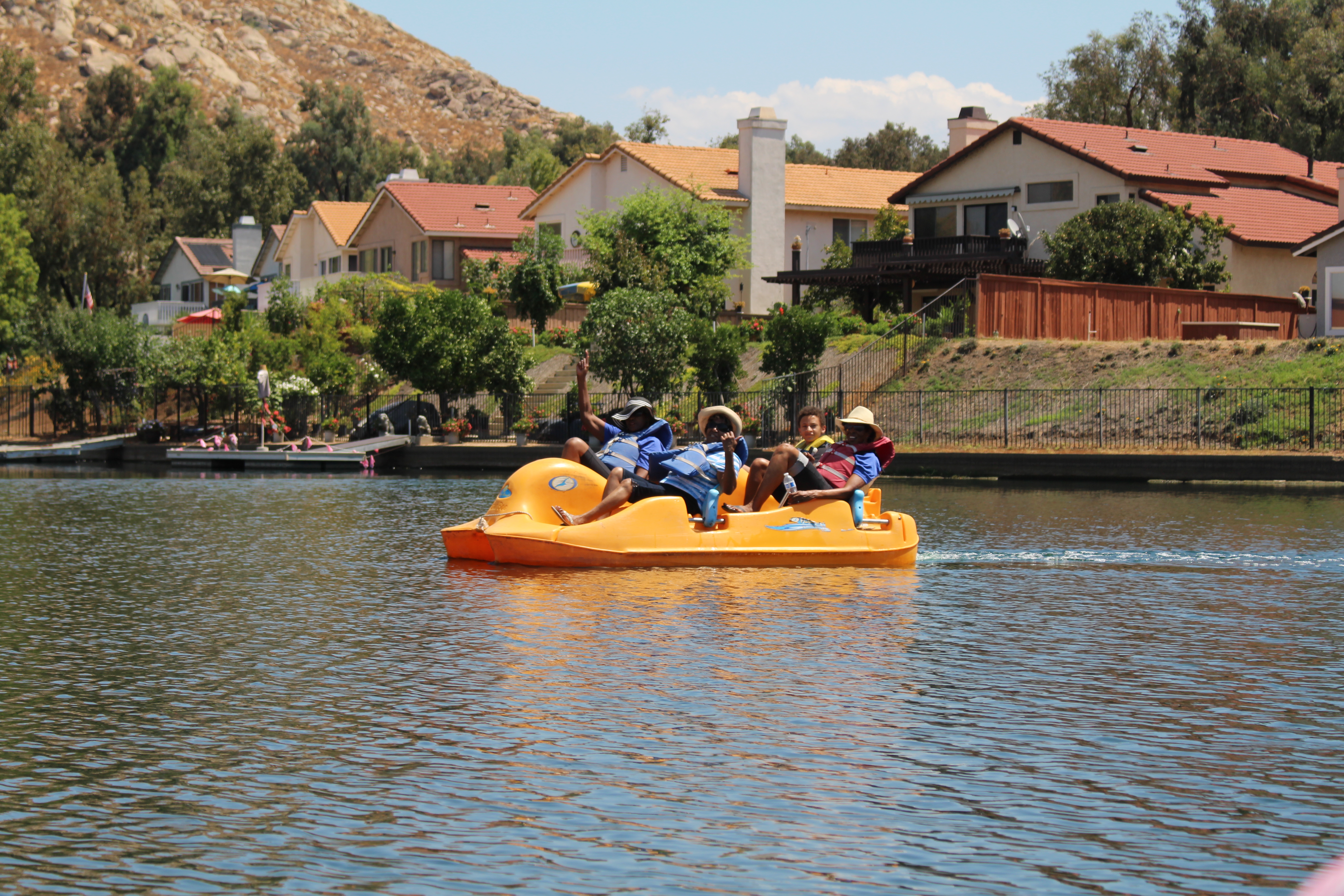 A third group driving a paddle boat on the lake