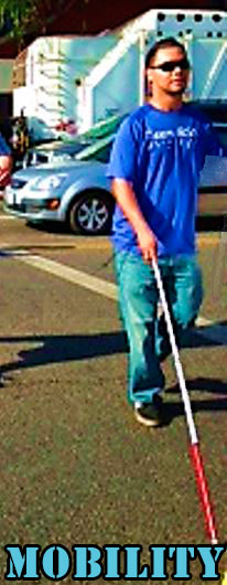 A blind man walks across the street using his white cane.